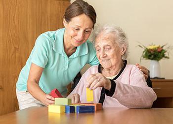 Senior woman plays with building blocks