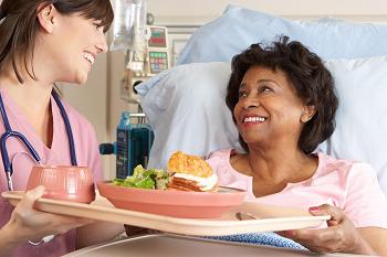 护士为老年女性病人提供营养膳食