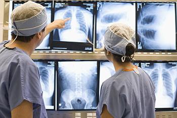 Orthopedic surgeons examining spine x-ray
