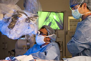 金宝搏手机登录's Dhruv Singhal, MD performs surgery on a patient with his colleague looking on.