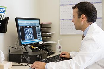 安德鲁一. 医学博士Wagner检查了一位金宝搏手机登录病人的x光片.